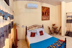 a bedroom with a bed and a table at Kangaroo Pouch Beach Resort in Busua