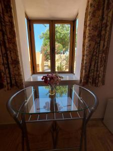 a vase of flowers on a glass table in front of a window at Mi Casa in Turre