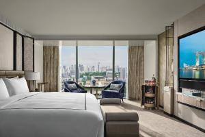 シンガポールにあるMarina Bay Sandsのベッドと大きな窓が備わるホテルルームです。