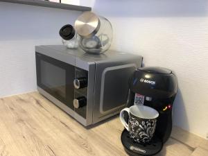 a coffee maker next to a microwave with a coffee mug at Studio proche centre-ville 2 in Reims