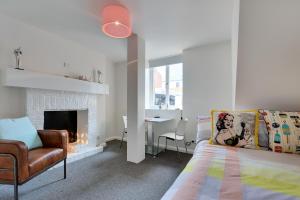 a bedroom with a bed and a chair and a fireplace at Portsea Place in Hobart