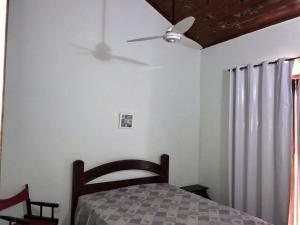 1 dormitorio con ventilador de techo y 1 cama en Casa Duplex a 450m da Praia do Peró - Cabo Frio, en Cabo Frío