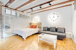 1 dormitorio con cama, sofá y reloj en Mendoza, en Valencia