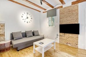 a living room with a couch and a clock on the wall at Mendoza in Valencia