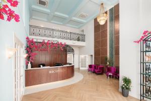 um átrio com uma área de recepção com cadeiras roxas em Bononia Estate Winery & Resort 
