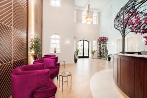 a lobby with purple chairs and a bar at Bononia Estate Winery & Resort 