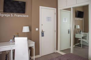 a room with a bedroom with a sink and a mirror at O'Porto Seven - Guest House in Porto