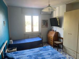 1 dormitorio con 2 camas, TV y ventana en Villa Marie Claire en Ischia