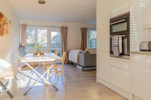 a kitchen and living room with a table and chairs at Modern 2 BD w/ Garden in the Heart of Tetbury! in Tetbury
