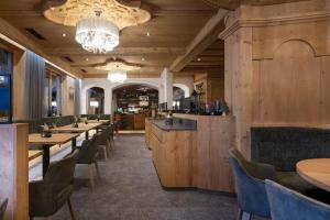 een restaurant met houten muren en tafels en stoelen bij Sepp & Hannis Suiten im Dorf in Neustift im Stubaital
