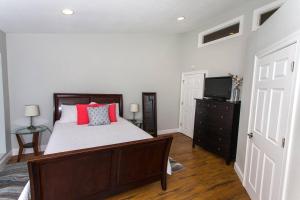 - une chambre avec un lit doté d'oreillers rouges et une télévision dans l'établissement Cozy Retreat-348 Miracle Strip Pkwy SW, Suite 8A, FT Walton Bch, FL 32548, à Fort Walton Beach