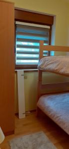 a bedroom with two bunk beds and a window at Apartman Vigo,Fužine in Fužine