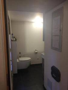 La salle de bains est pourvue de toilettes blanches et d'un lavabo. dans l'établissement Ferienhaus Häxenäscht mit Sauna, Hotpot und Schopf mit gemütlichem Stübli und Pizzaofen, 