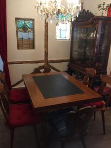 a dining room table with chairs and a chandelier at Ferienhaus Häxenäscht mit Sauna, Hotpot und Schopf mit gemütlichem Stübli und Pizzaofen 