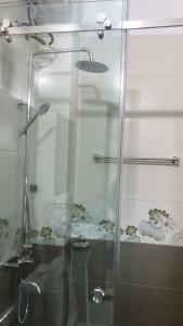 prysznic ze szklanymi drzwiami i umywalką w obiekcie Nhà Nghỉ Hương Trà Minh Đài 