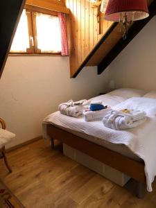 a bedroom with a bed with towels on it at Ferienhaus Häxenäscht mit Sauna, Hotpot und Schopf mit gemütlichem Stübli und Pizzaofen 