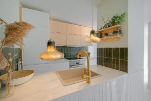 cocina con fregadero y 2 luces colgantes en Diva in de Duinen - Park Duinland Sint Maartenszee, en Sint Maartensvlotbrug