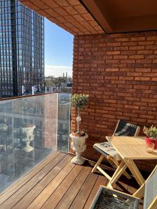 a balcony with a wooden table and a brick wall at ApartmentInCopenhagen Apartment 1527 in Copenhagen