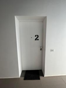 une porte blanche avec le numéro deux sur elle dans l'établissement Green space studio in the center, à Rome