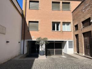 un edificio de ladrillo con un árbol en maceta delante de él en GreenSpace Romantic Studio - Piazza del Popolo, en Roma
