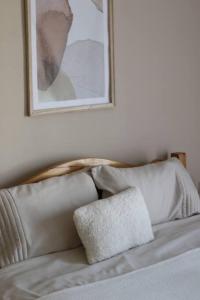 uma cama com uma almofada e uma fotografia na parede em City Center - TERRA Apartment em Pristina