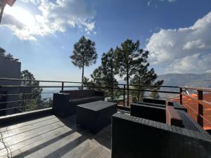 a balcony with benches and a view of the mountains at The Realtors Inn Luxurious Cottage Murree in Murree