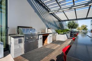 an outdoor kitchen with a grill and red chairs at Oakland 1BR w AC WD Sky Deck next to BART SFO-524 in Oakland