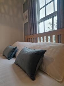 a bed with two pillows in front of a window at Small Cottage close to Carbis Bay Beach & St Ives in Carbis Bay