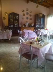 uma sala de jantar com mesas roxas e cadeiras brancas em Hosteria Amaneseres em Capilla del Monte