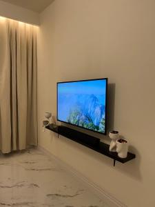 een flatscreen-tv zittend op een muur bij Ritaj Hotel Suites in Riyad