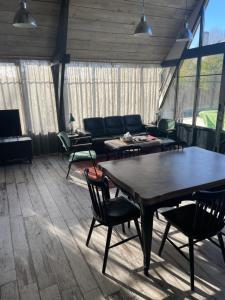 a living room with tables and chairs and a couch at L’Aubépine in Saint-Gervais-la-Forêt