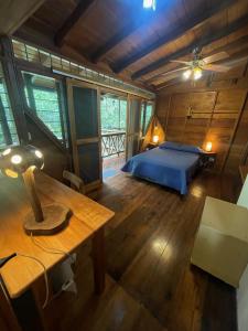 a bedroom with a bed and a table in a room at Caoni riverside Lodge in Puerto Quito