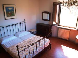 um quarto com uma cama, um espelho e uma janela em Cas'al Verde em Fonterutoli
