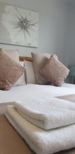 Una cama con mantas blancas y almohadas. en The Dundonnell Hotel, en Dundonnell