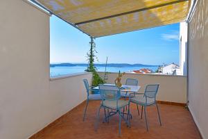 uma mesa e cadeiras numa varanda com vista para o oceano em Apartments Biba Hvar em Hvar