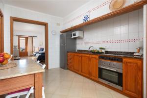 La cuisine est équipée d'armoires en bois et d'un réfrigérateur en acier inoxydable. dans l'établissement Mare de Deu del Carme 18, à El Estanyol