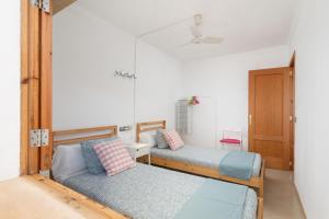 a room with two beds and a mirror at Mare de Deu del Carme 18 in S'Estanyol de Migjorn
