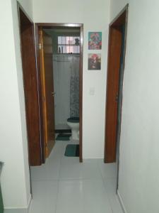pasillo de un baño con aseo y puerta en Casa do Léo 1 - Temática México e África, en João Pessoa