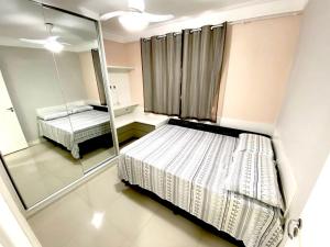 1 dormitorio con 2 camas y espejo en Pérola de Piatã, en Salvador