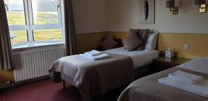 a hotel room with two beds and a window at The Dundonnell Hotel in Dundonnell