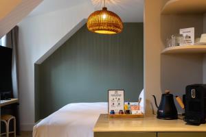 バーゼルにあるBoutique Hotel Waldhaus beider Baselの緑色のアクセントの壁のベッド1台が備わるベッドルーム1室