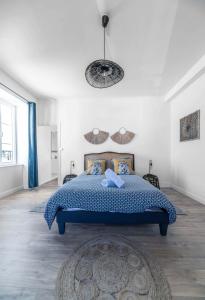 a bedroom with a blue bed in a white room at La Grande Maison Gannat in Gannat
