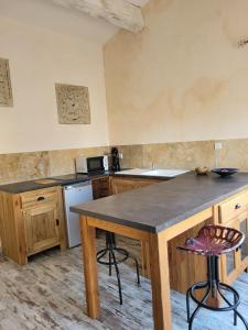 a kitchen with a table and a counter top at Studios et chambre La Sauvasse in Vagnas