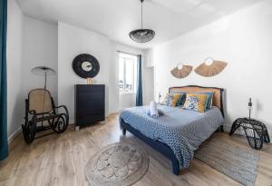 a bedroom with a bed and a chair in it at Grande Maison Gannat - Maison ou Appartements en Centre ville in Gannat