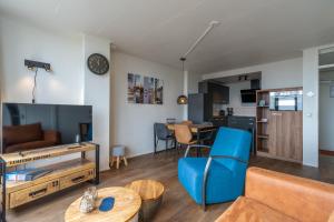 ein Wohnzimmer mit einem Sofa und einem Tisch in der Unterkunft Appartementencomplex Juliana 122 in De Koog