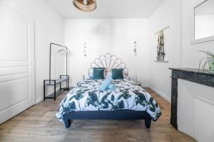 a bedroom with a bed with blue pillows at Grande Maison Gannat - Maison ou Appartements en Centre ville in Gannat