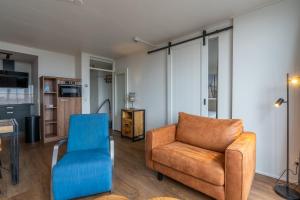 ein Wohnzimmer mit einem Sofa und einem Stuhl in der Unterkunft Appartementencomplex Juliana 122 in De Koog
