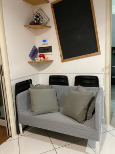 un divano in una stanza con una lavagna sul muro di TheMaki'sHouse a Fiumicino