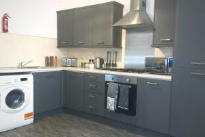 a kitchen with a washing machine and a washer at Stylish Apartment in City Centre with Parking in Preston