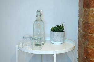 uma garrafa e copos numa prateleira branca com uma planta em Stylish Apartment in City Centre with Parking em Preston